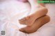 A close up of a person's feet on a bed.