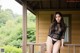 A woman in a black lingerie posing on a porch.