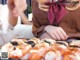 A woman sitting at a table with a tray of sushi.